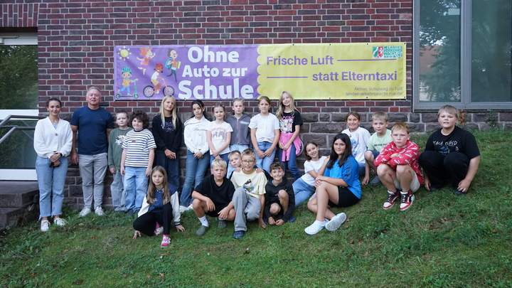 Kinder mit dem Schulleiter auf einer Wiese