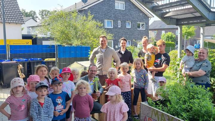 Kinder vor einem Hochbeet
