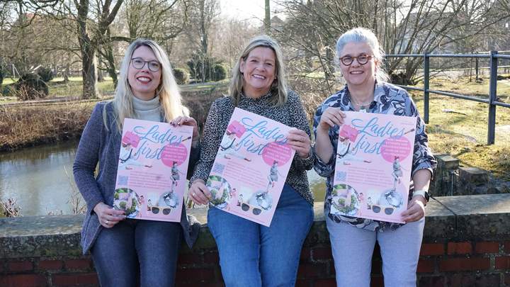 Drei Frauen präsentieren das Plakat