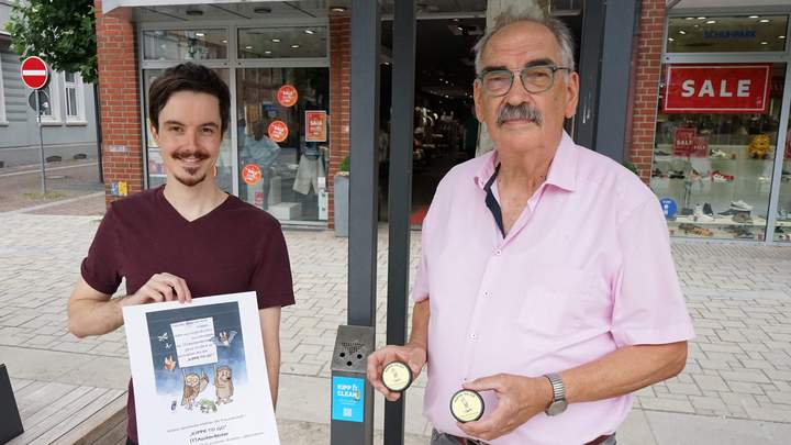 Zwei Männer zeigen den Aufkleber