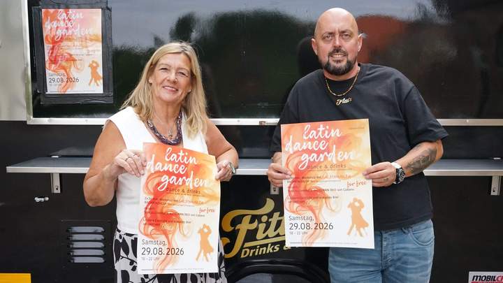 Veranstalter zeigt Plakat zum Latin Dance Garden