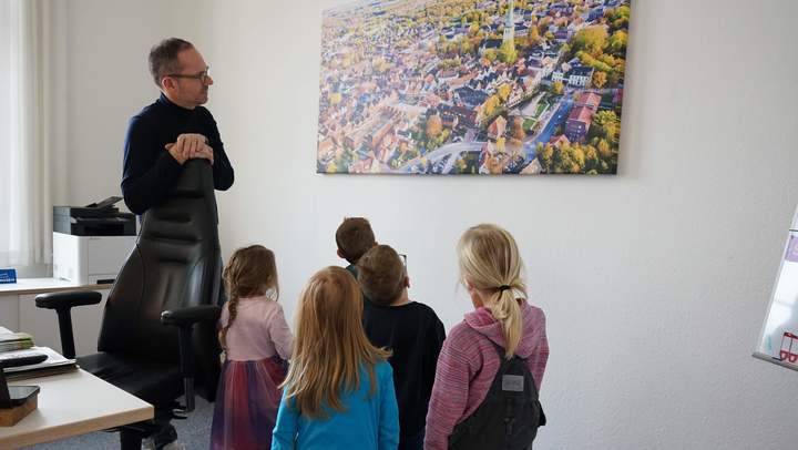 Bürgermeister mit den Kindern vor einem Bild