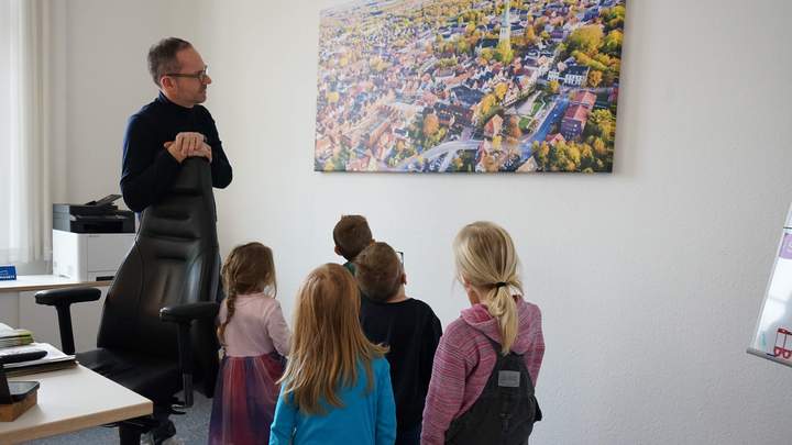 Bürgermeister mit den Kindern vor einem Bild