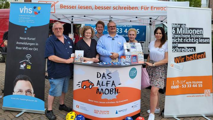 Menschengruppe steht vor dem Mobil